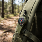 Pocket Button Compass clipped to a pack